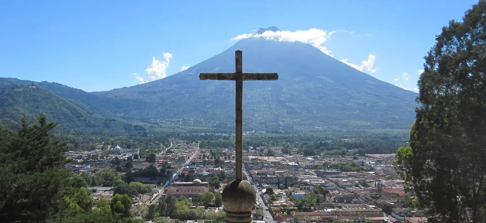 The cross above Antigua with Volcán de Agua rising beyond the city