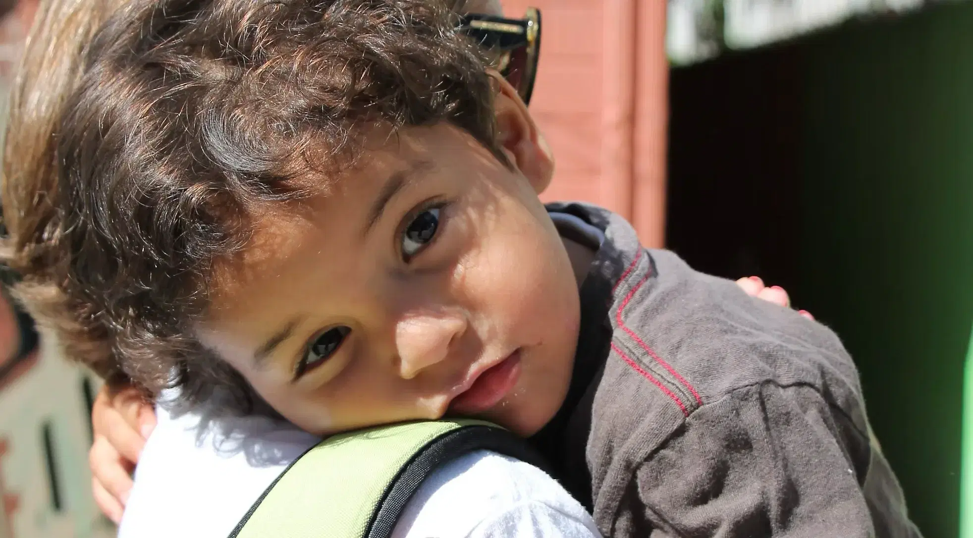 A child resting on a volunteer's shoulder