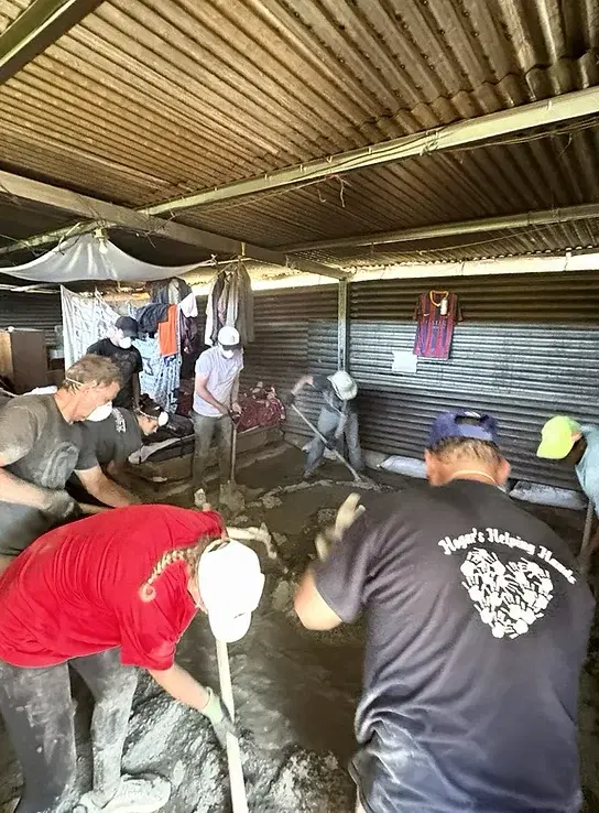 A mission team pouring a new concrete floor in a village home