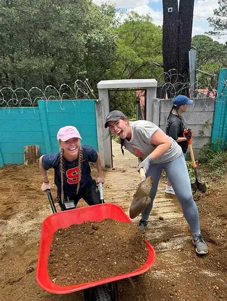 Volunteers hauling earth during a construction project