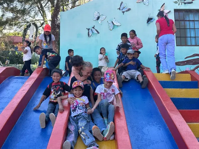 Children piling down the painted slide at the home