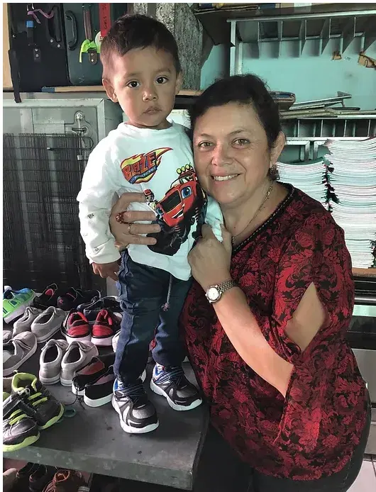 Karen Rodas holding a young child at the children's home
