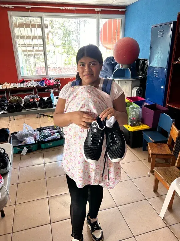 A girl with her new sneakers in the shoe room