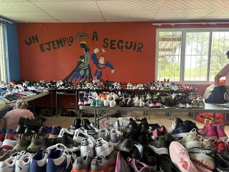 Tables covered in hundreds of donated shoes