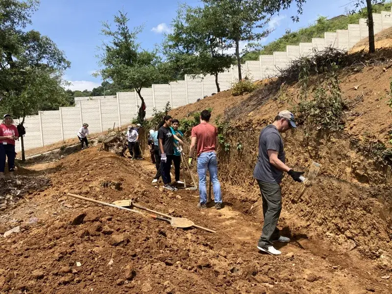 Volunteers digging out the hillside for the trade school's retaining walls