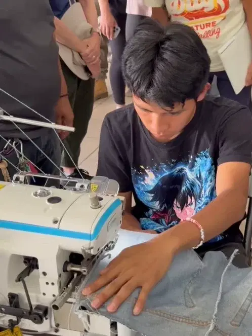 A student at a sewing machine in the trade school