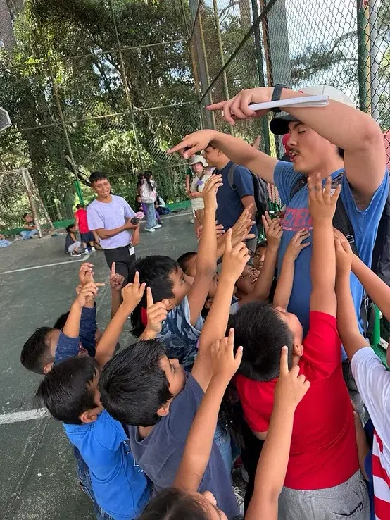 Children reaching up during games at Vacation Bible School in Aguacate